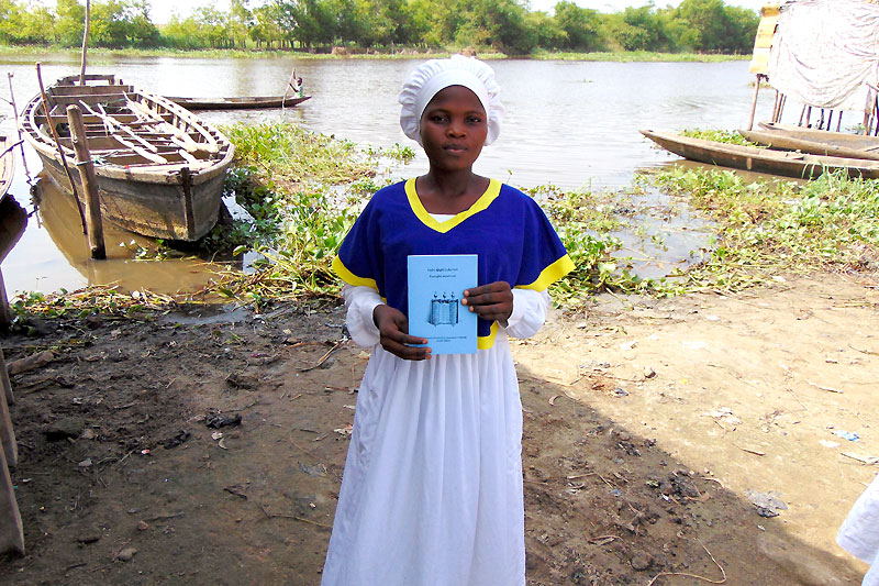 Benin Tofinu girl holding Scripture portions booklet